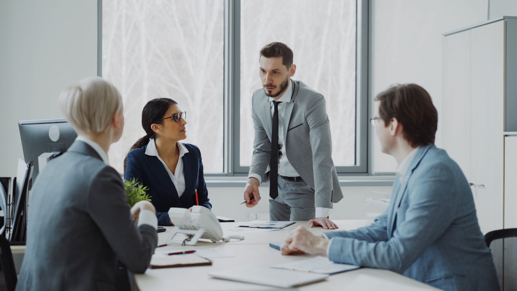 Professionals in a serious business discussion in a bright office